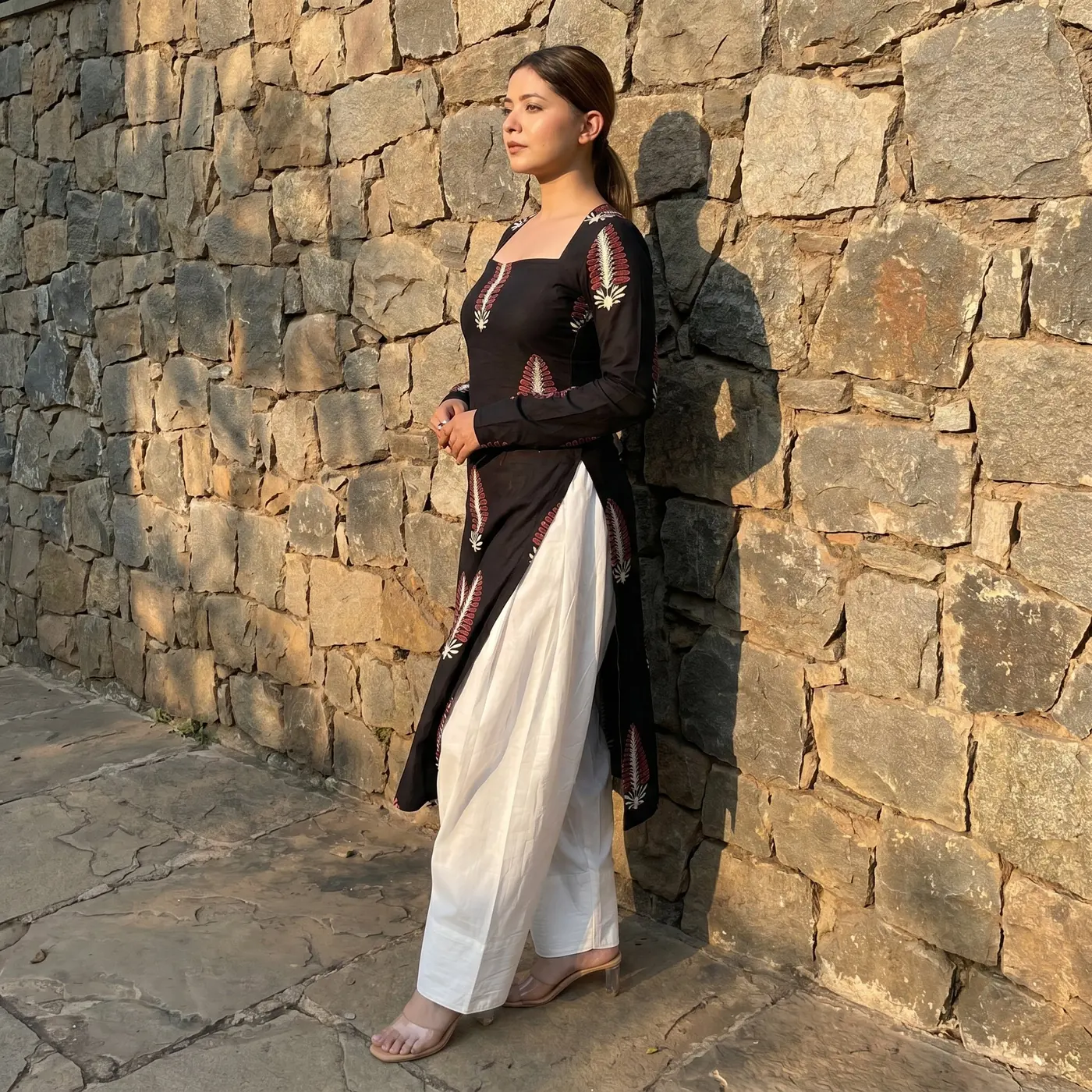 Fashion lifestyle image: white salwar stone wall